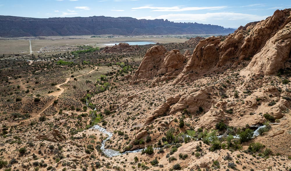 aerial showing water flowing down Faux Falls toward Ken's Lake, south of Moab, Utah