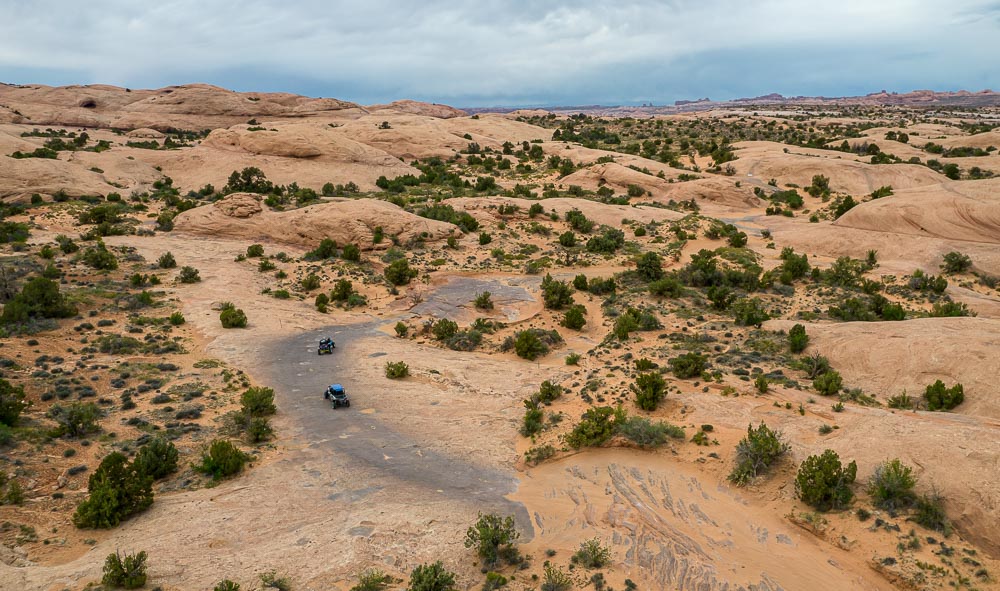 two off-highway vehicles drive through the Hell's Revenge in Sand Flats Recreation Area near Moab, Utah