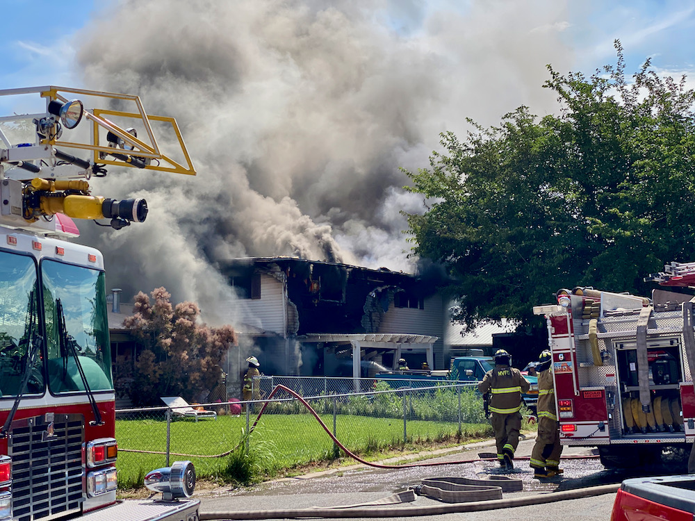 a house in Moab billows with smoke as firefighters and firetrucks on scene work to respond