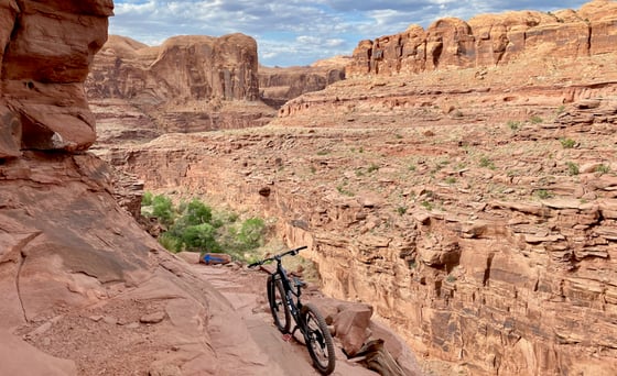 a bike stands at the ledge of a cliff along Captain Ahab, a bike trail in Moab, Utah