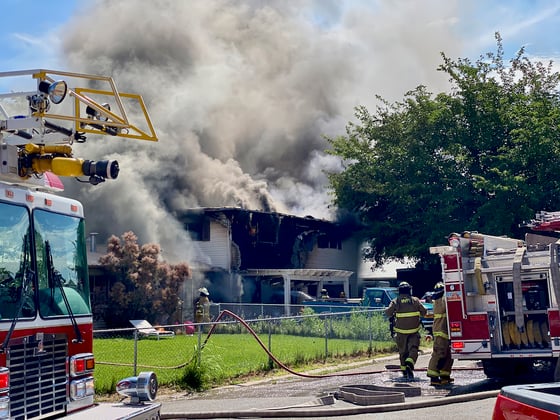 a house in Moab billows with smoke as firefighters and firetrucks on scene work to respond