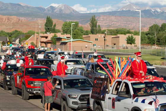 Grand County High School seniors sit atop and in their decorated vehicles, in line in front of the school during the Class of 2020 graduation ceremony